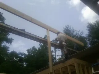 Carpenter setting a ridge beam over a new addition frame — Ice Dam Removal by Roofing Brothers in Glendale Springs