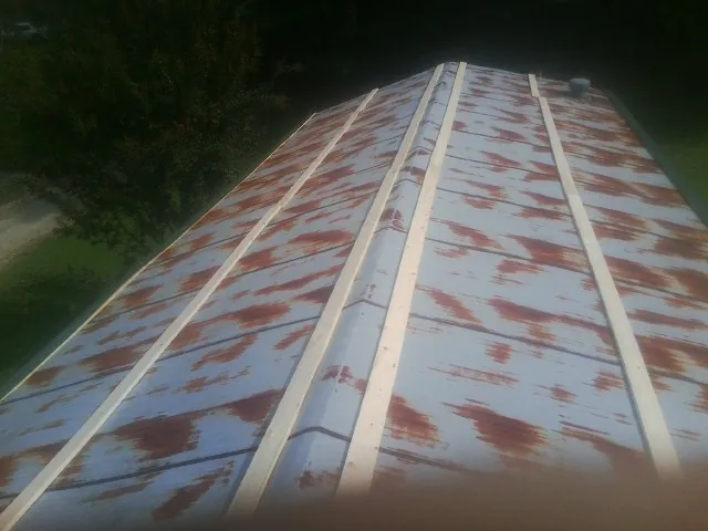 Rusted metal roof panels with new wood purlins before replacement — Storm Damage Roof Repair in Glendale Springs by Roofing Brothers