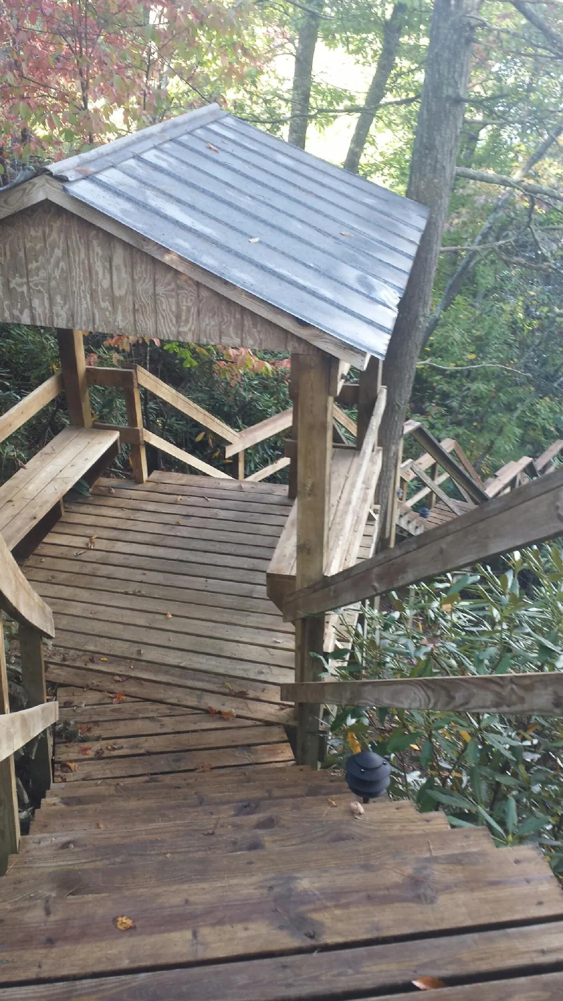 Metal roofed shelter over wooden steps on a wooded walkway — Skylight Repair & Installation work by our crew in Glendale Springs