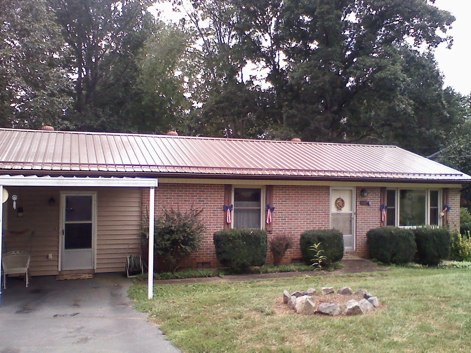Bronze metal roof and carport on a brick ranch home — Roof Repair work by our crew in Glendale Springs